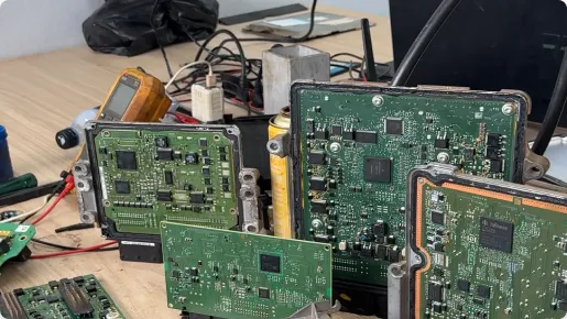 Detalhe de um módulo de injeção eletrônica (ECU) sendo conectado a um equipamento de diagnóstico para reparo e configuração.